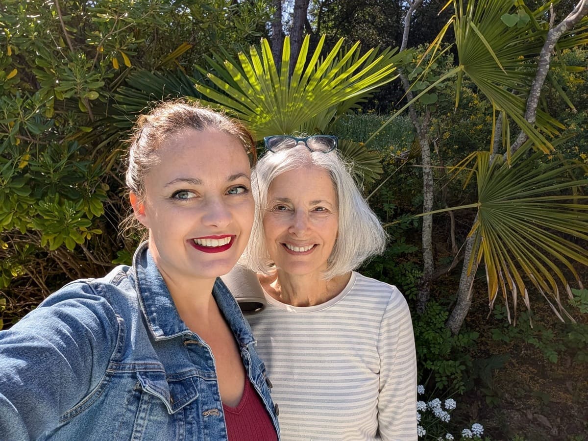 Photo of an immersion student with her french teacher in front of the garden