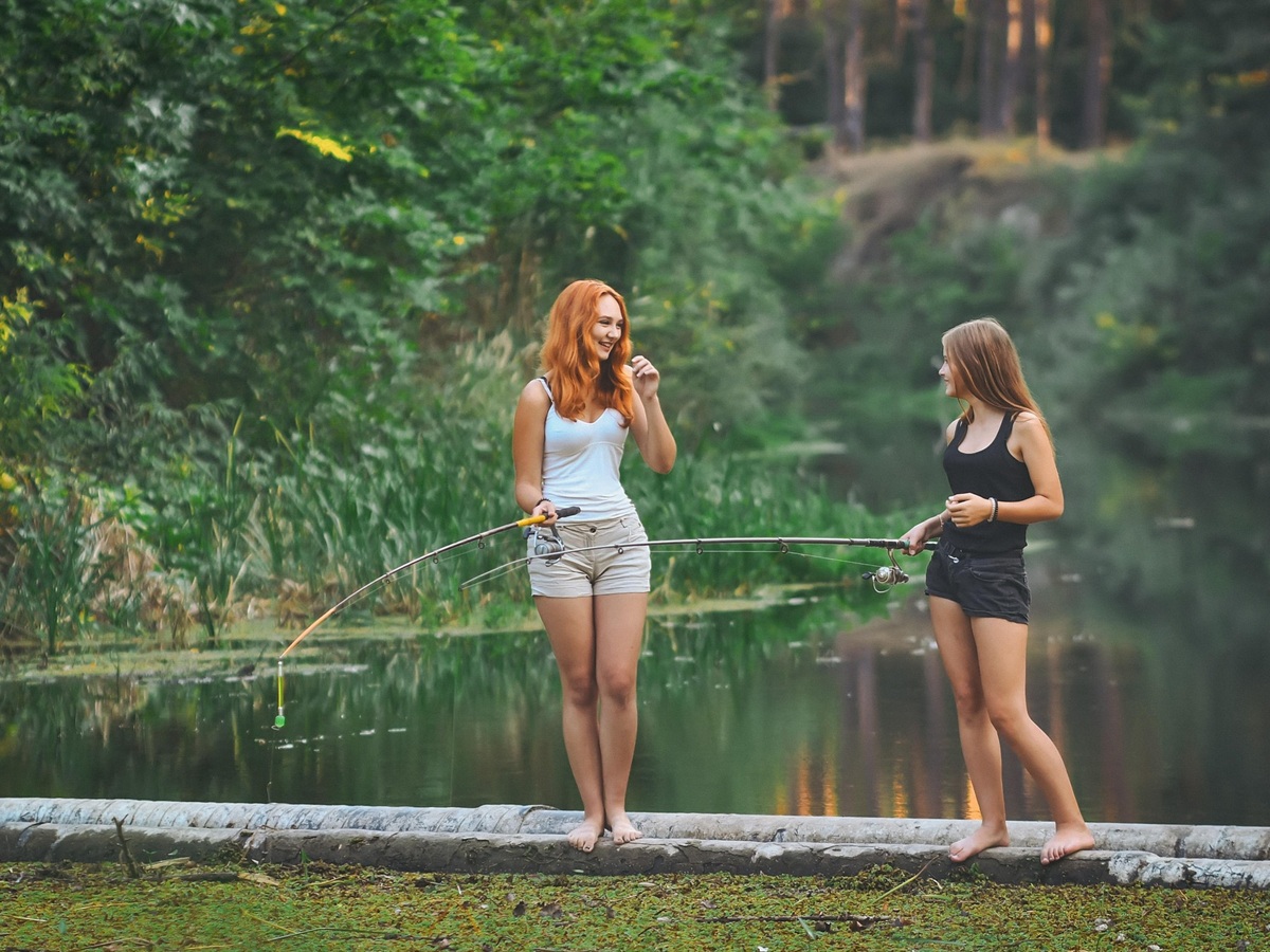 Two women fishing by the water in Occitanie during a French immersion experience